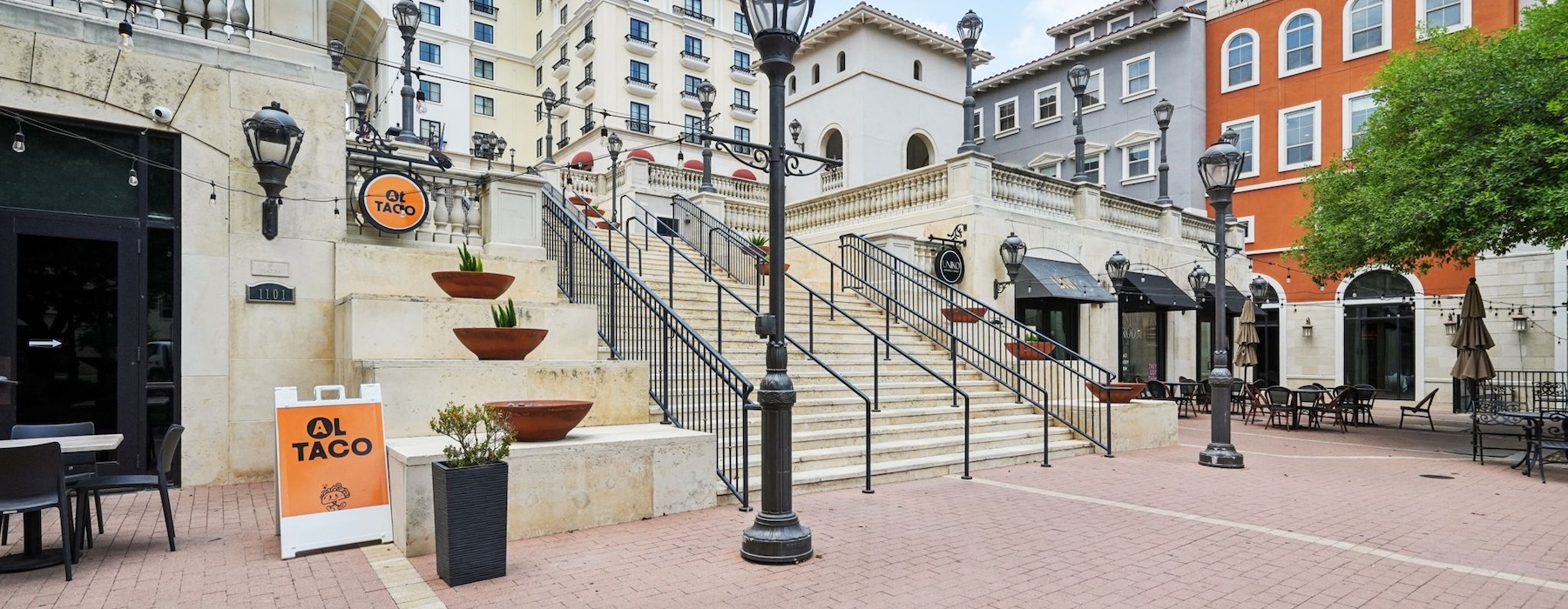 a group of buildings and stairs and a tree