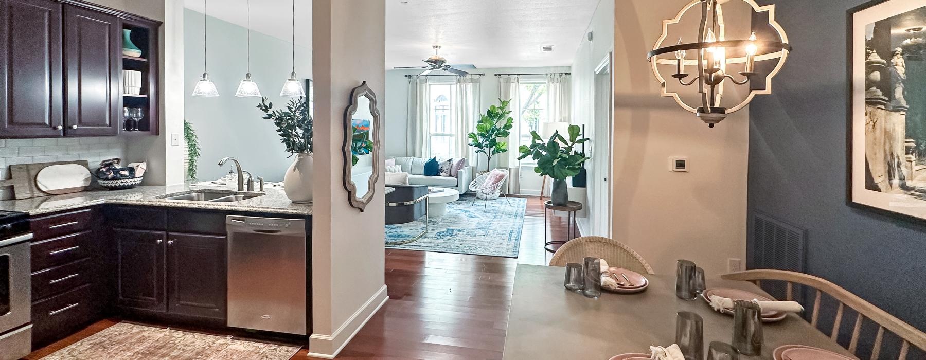 a large living room with a dining table and a chandelier